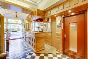 a hallway with a kitchen with a checkered floor at Hôtel du Square d'Anvers in Paris