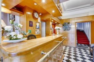 a kitchen with a wooden counter top and a checkered floor at Hôtel du Square d'Anvers in Paris