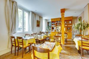 a restaurant with yellow tables and chairs in a room at Hôtel du Square d'Anvers in Paris