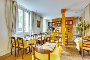 パリにあるオテル デュ スクワール ダンヴェールの黄色のテーブルと椅子が備わるレストラン