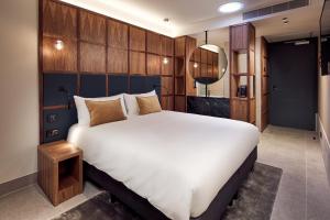 a bedroom with a large bed and a large window at Met Hotel Amsterdam in Amsterdam