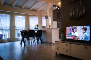 Televízia a/alebo spoločenská miestnosť v ubytovaní L'Attico del Lago
