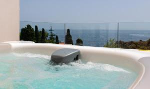 a jacuzzi tub with a controller in it at Iancu Charme Apartments in Taormina