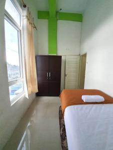 um pequeno quarto com uma cama e uma janela em KoolKost Syariah At Medan Johor em Delitua