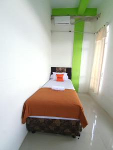 um quarto com uma cama com paredes laranja e verde em KoolKost Syariah At Medan Johor em Delitua