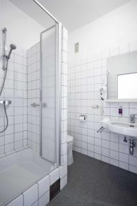 y baño con ducha, aseo y lavamanos. en Hotel Waldheimat, en Gallneukirchen