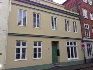 ein gelbes Haus mit grüner Tür auf einer Straße in der Unterkunft Ferienwohnung Bode in Lübeck