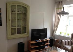 a living room with a tv and a cabinet at Ferienwohnung Bode in Lübeck