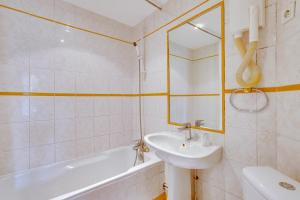 a bathroom with a sink and a tub and a toilet at Hôtel du Square d'Anvers in Paris