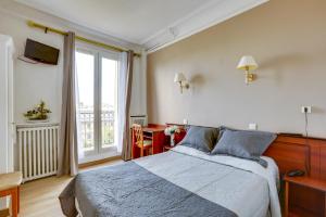 a bedroom with a bed and a large window at Hôtel du Square d'Anvers in Paris