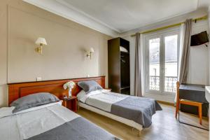 a bedroom with two beds and a window at Hôtel du Square d'Anvers in Paris