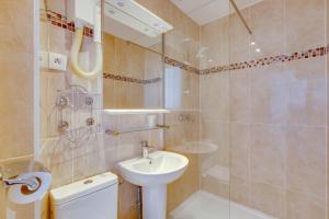 a bathroom with a sink and a toilet and a shower at Hôtel du Square d'Anvers in Paris
