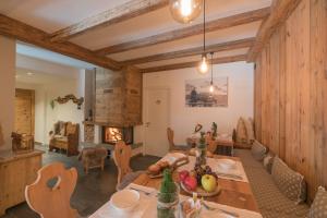 uma sala de jantar com uma mesa e uma lareira em B&B Al Baitin - Charme & Nature - em Santa Caterina Valfurva
