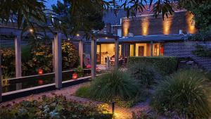 a house with a patio at night with lights at Downtown Hideaway, B&B Grand Deluxe in Eindhoven