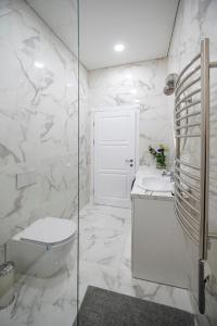 een witte badkamer met een toilet en een wastafel bij Botanical garden apartment in Kaunas