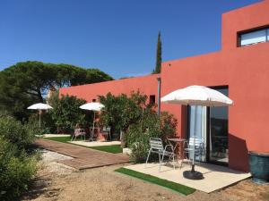 - un bâtiment avec une table, des chaises et un parasol dans l'établissement Chambres d'hôtes VUE MER Mer à 2 min à pied, à Sainte-Maxime