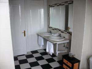 La salle de bains blanche est pourvue d'un lavabo et d'un miroir. dans l'établissement Hotel Neguri, à Getxo