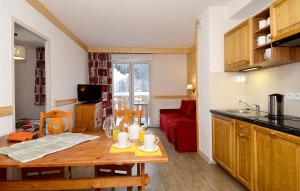 uma cozinha e sala de estar com uma mesa de madeira e uma mesa em travelski home select - Résidence Les Bergers em Saint-Sorlin-dʼArves