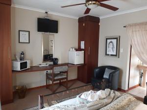a living room with a couch and a desk with a microwave at Seldre Guest House in Nigel