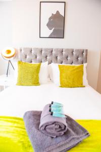 ein Bett mit gelben Kissen und einer Decke darauf in der Unterkunft 4 Bed - 2 Bathrooms 1 Walk in Shower - lots of Parking - Long Stays Welcome in Ipswich