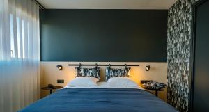Live Hotels Bordeaux Lac في بوردو: غرفة نوم بسرير كبير وبجدار اخضر