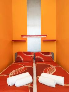 twee bedden in een kamer met oranje en wit bij Highlight Apartment Naschmarkt in Wenen