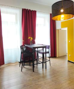 ein Esszimmer mit einem Tisch, Stühlen und roten Vorhängen in der Unterkunft Highlight Apartment Naschmarkt in Wien