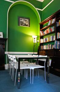 een groene kamer met een tafel en stoelen in een bibliotheek bij YHA London St Paul's in Londen