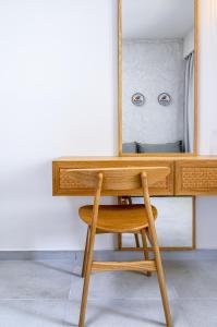 a wooden desk with a mirror and a chair at Pedi Beach Hotel in Symi