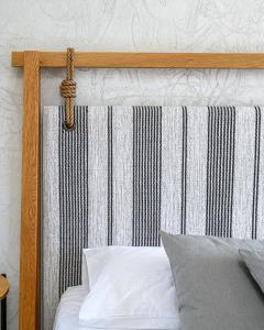 a wooden headboard with a rope hanging on it at Pedi Beach Hotel in Symi