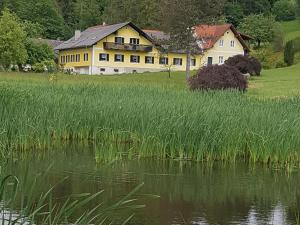 a large yellow house sitting next to a field of grass at Frühstückspension Krump in Bad Waltersdorf