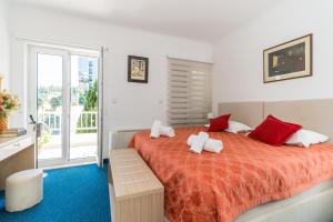 a bedroom with a large bed with red and white pillows at Hotel Dubrovnik in Dubrovnik