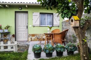 a table and chairs in front of a green house at Casa de Arriba in Rinlo