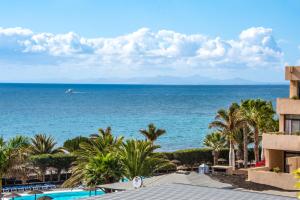 
a beach with palm trees and palm trees at Hotel Beatriz Playa & Spa in Puerto del Carmen
