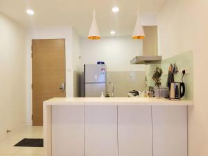 a kitchen with white cabinets and a refrigerator at Skypod Residence Puchong in Puchong