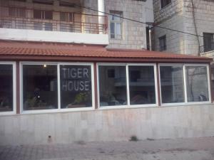a tiger house with a sign in the window at Tiger House Guest House in Bcharré