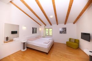 a bedroom with a bed and a green chair at Villa francesca in Starigrad