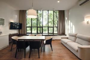 a living room with a couch and a table and chairs at W Sercu Krakowa Aparthotel in Kraków