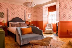 a bedroom with a bed and a chair at The Mitre, Hampton Court in Kingston upon Thames