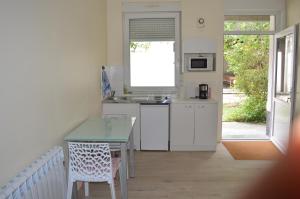 eine Küche mit einem Tisch, einem Tisch und einem Fenster in der Unterkunft Aux Thermes in Saint-Amand-les-Eaux