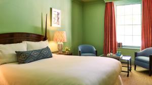 a hotel room with a bed and two chairs at The Mitre, Hampton Court in Kingston upon Thames