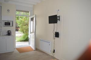 a living room with a tv on a wall at Aux Thermes, studio calme et paisible in Saint-Amand-les-Eaux