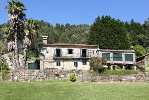 een oud stenen huis met een stenen muur bij Casa del Cura de Oliveira in Gondomar