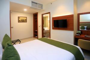 a hotel room with a bed and a television at Luxury Inn Arion Hotel in Jakarta
