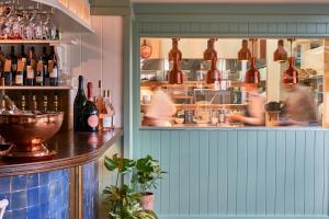 a restaurant with people in the kitchen and a counter at The Mitre, Hampton Court in Kingston upon Thames