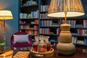a lamp on a table in a library with books at The Mitre, Hampton Court in Kingston upon Thames