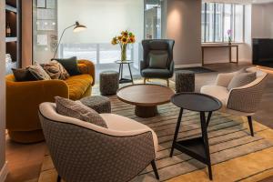 un vestíbulo con sofás, sillas y una mesa en The Resident Victoria, en Londres