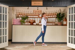 a woman is standing in front of a counter at The Mitre, Hampton Court in Kingston upon Thames