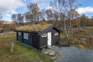 a black and white building with a grass roof at Besseggen Fjellpark AS in Maurvangen