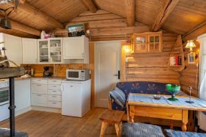 eine Küche mit weißen Schränken und einem Tisch im Zimmer in der Unterkunft Besseggen Fjellpark AS in Maurvangen